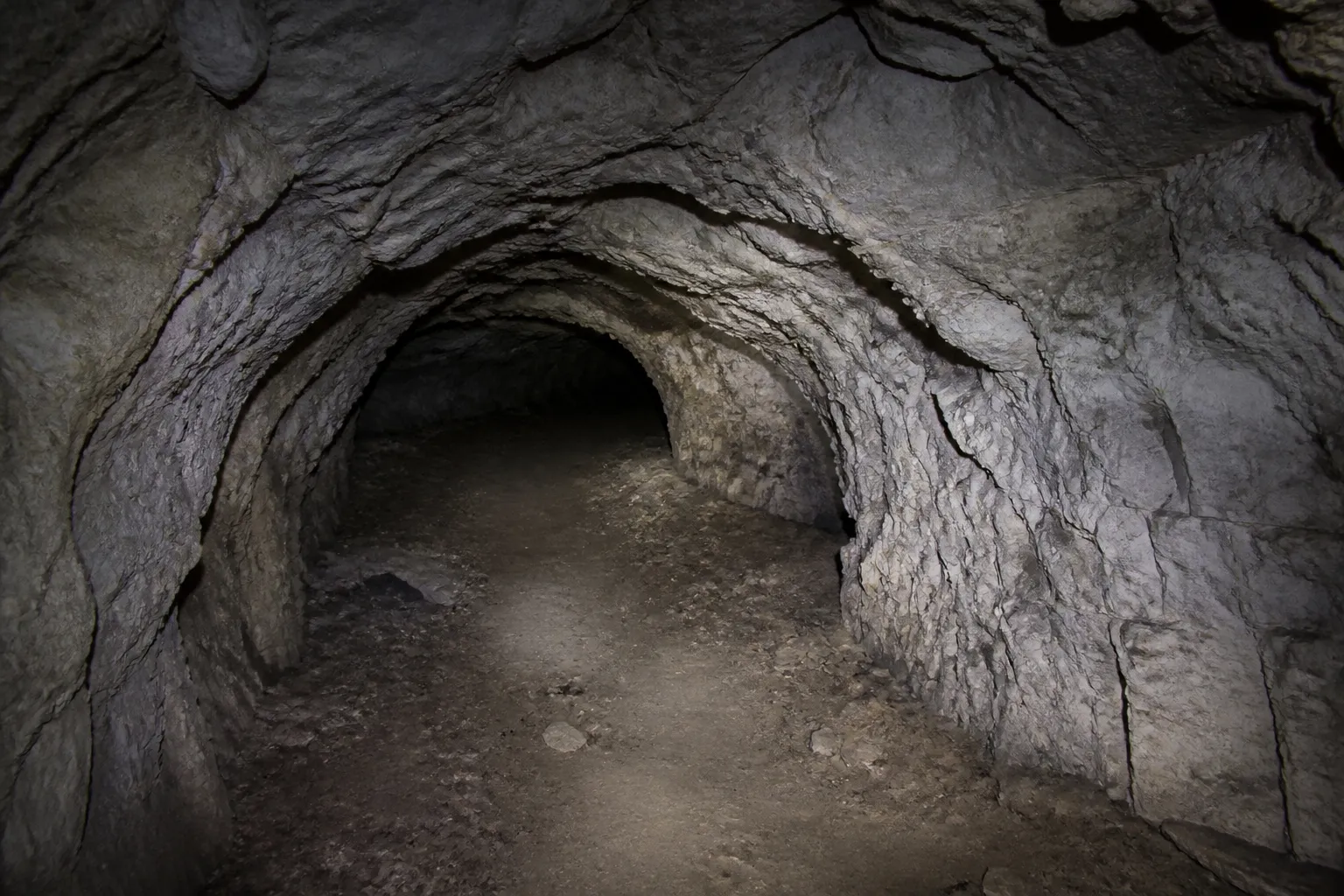 Cave voûtée en pierre éclairée par une lampe