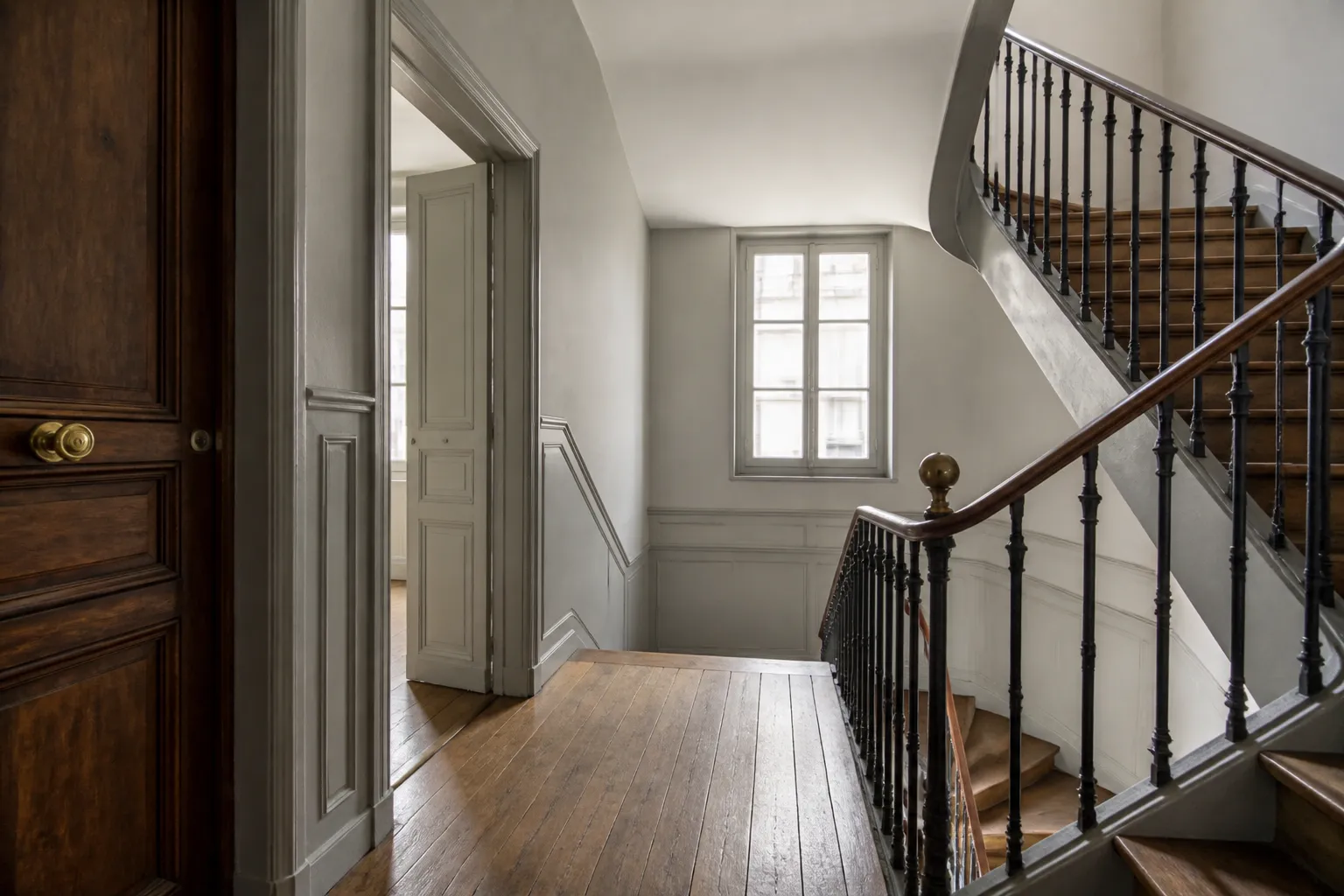 Palier d’un immeuble ancien avec escalier en bois