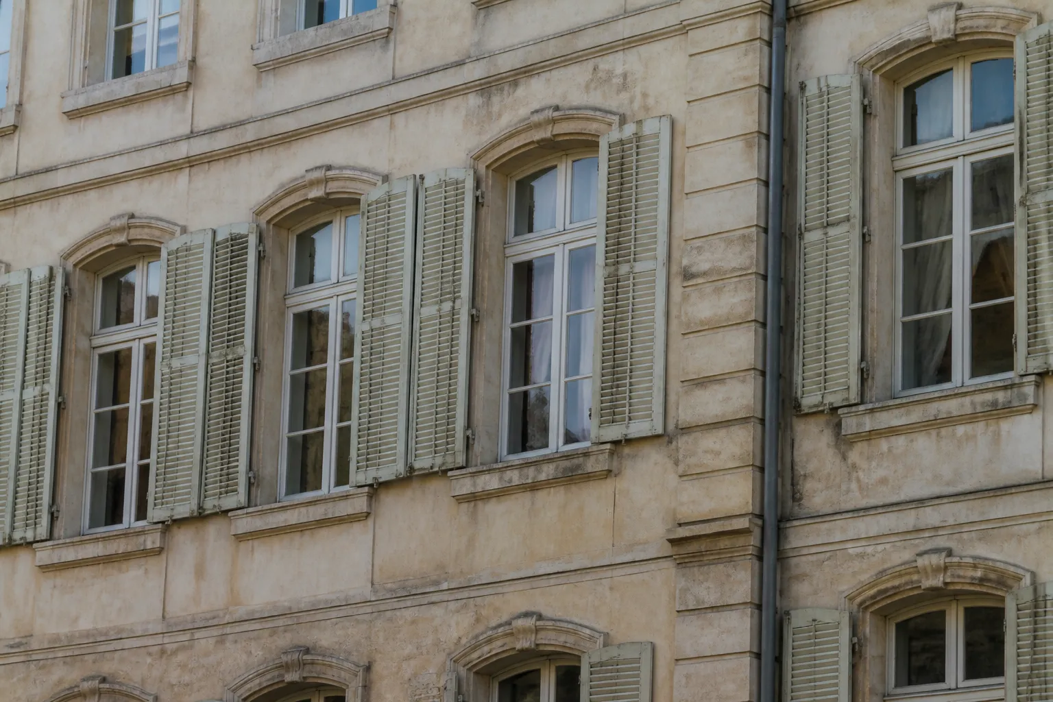 Immeuble ancien en pierre enduite avec fenêtres anciennes