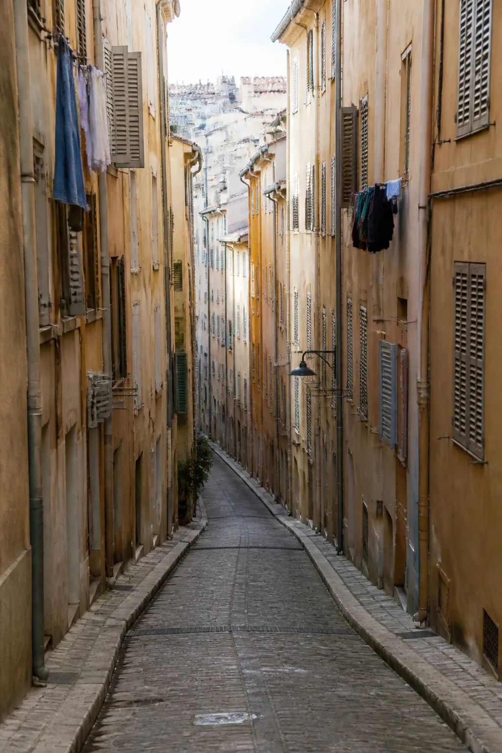 Ruelle en pente bordée d’immeubles anciens dans une ville provençale