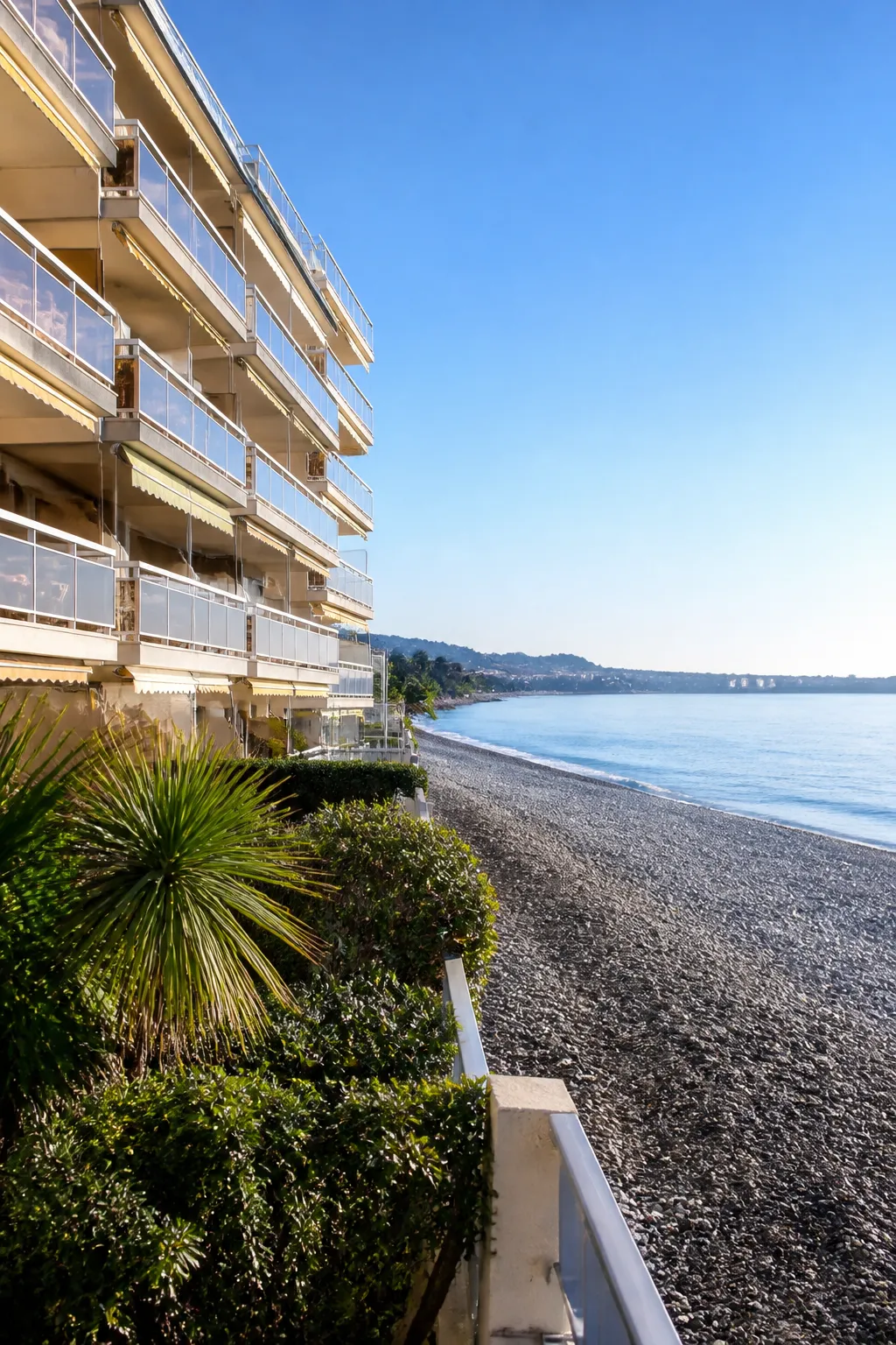 Résidence en bord de mer avec balcons face à une plage de galets