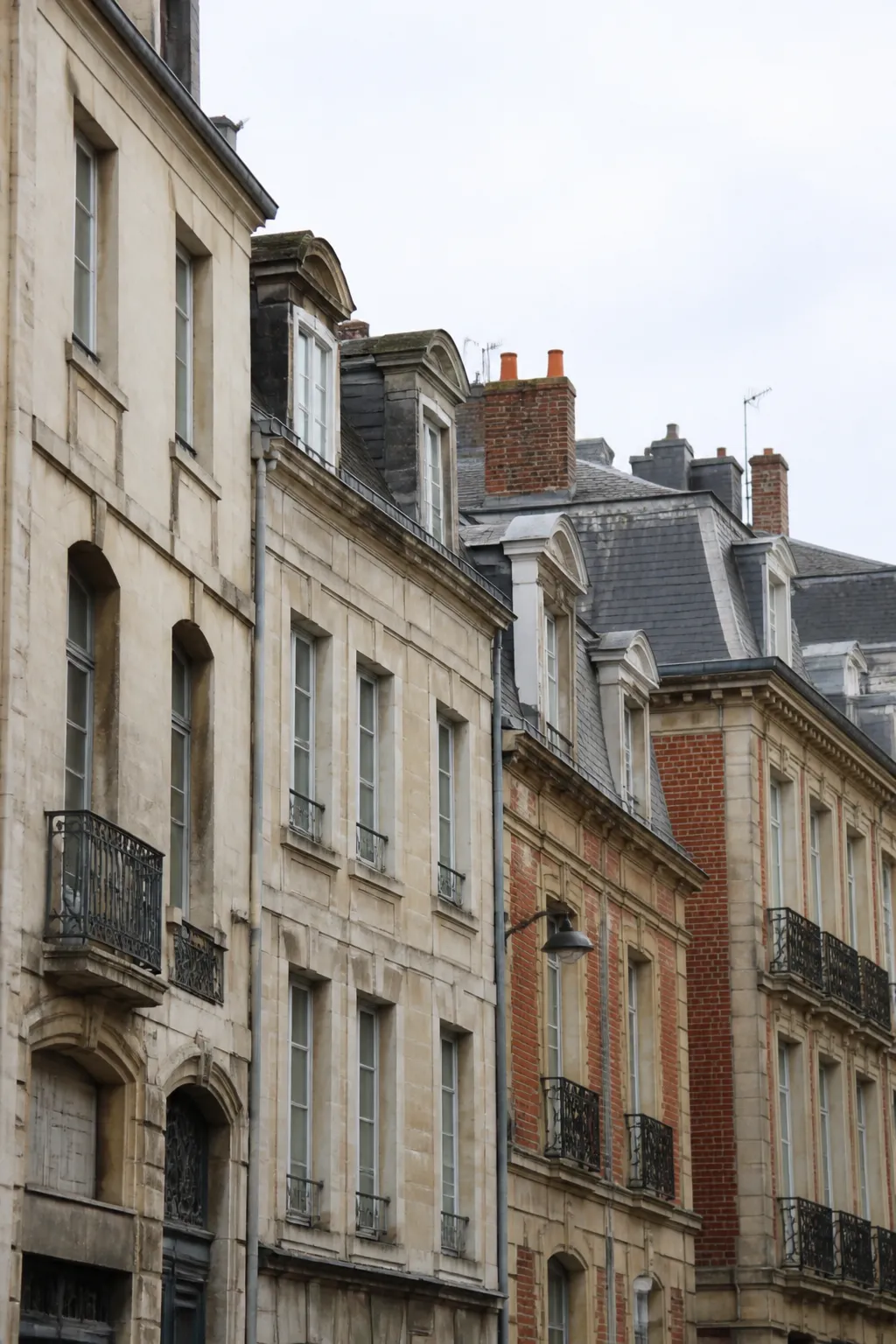 Façades d’immeubles anciens en pierre et brique dans une ville des Ardennes