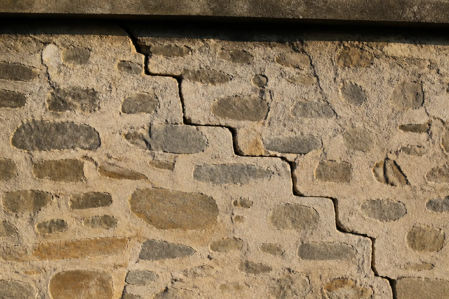Fissure en escalier dans un mur en moellons