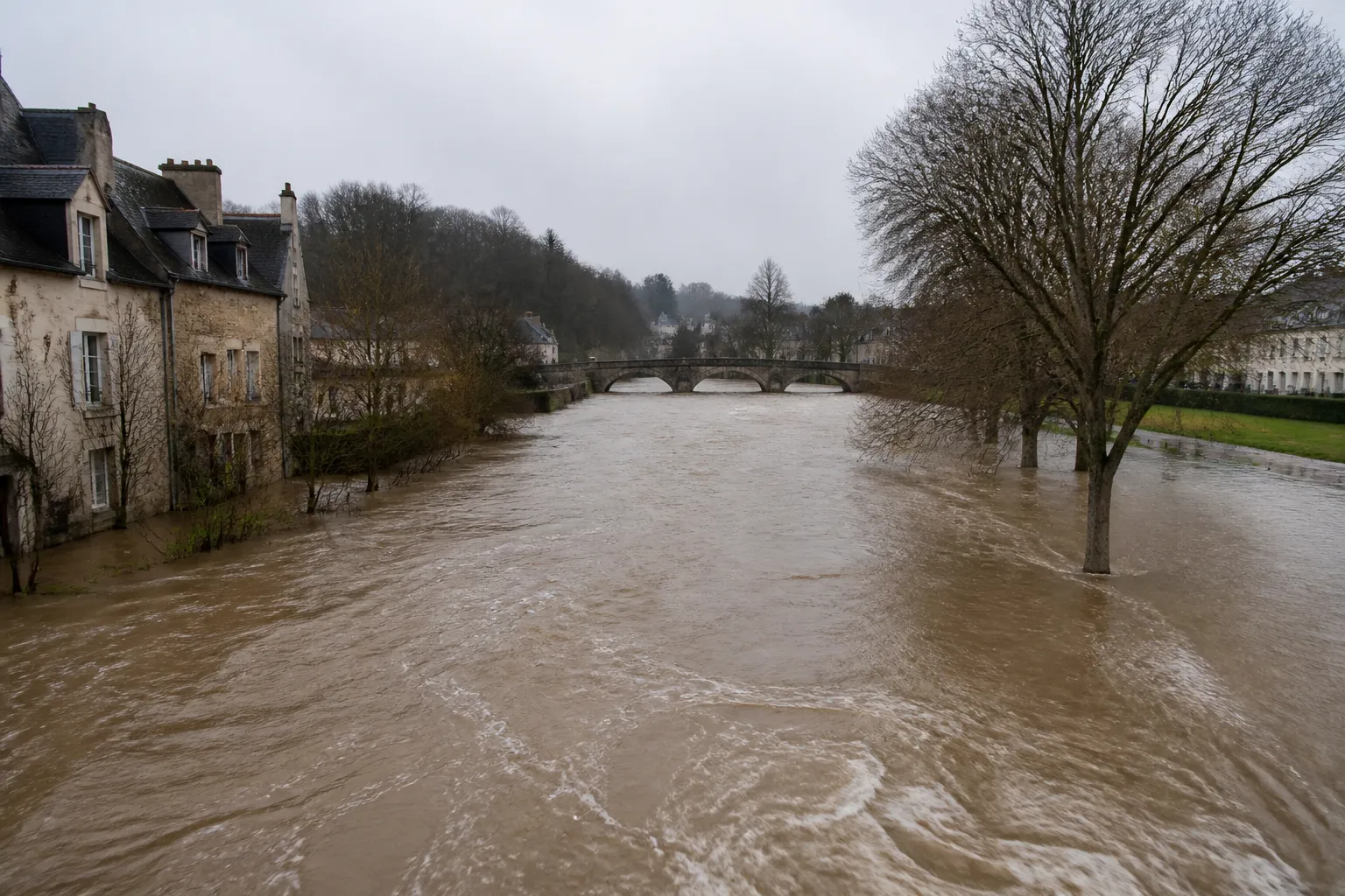 Rivière de vallée bordée de maisons après des pluies