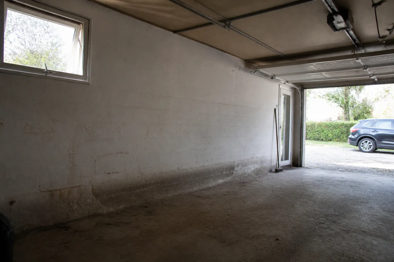 Garage en rez-de-chaussée d’une maison avec mur en partie basse