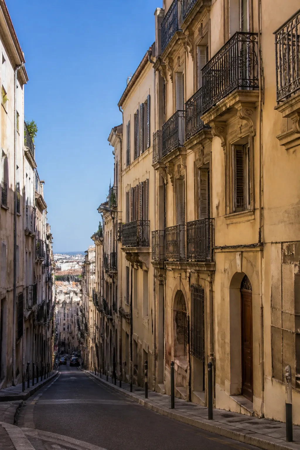 Immeubles anciens à façades enduites dans une rue en pente d’une grande ville méditerranéenne