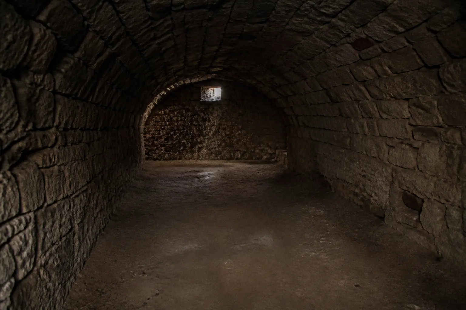 Cave voûtée en pierre avec sol en terre battue