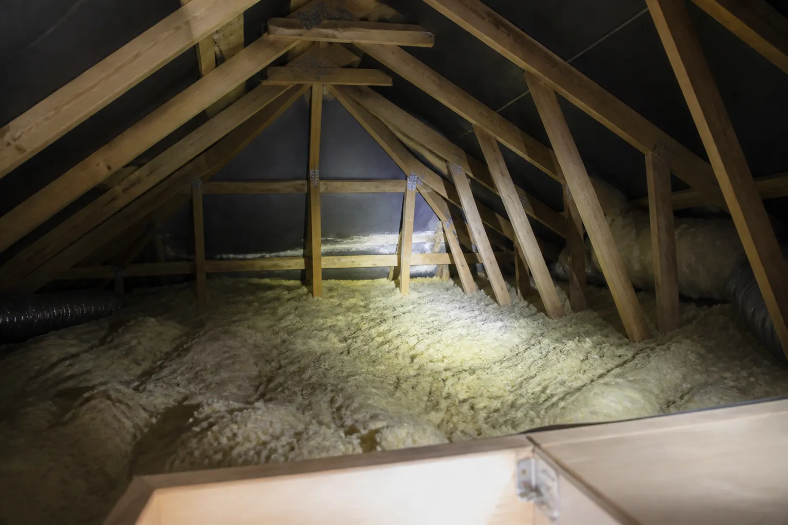 Combles isolés observés à la lampe depuis une trappe