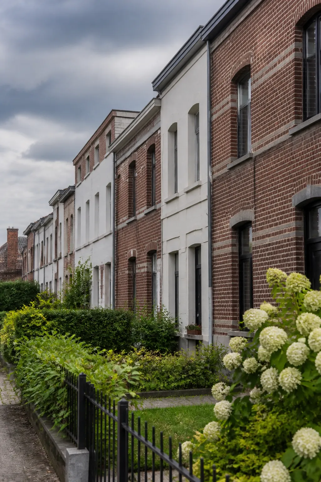 Rangée de maisons mitoyennes en brique et enduit avec petits jardins