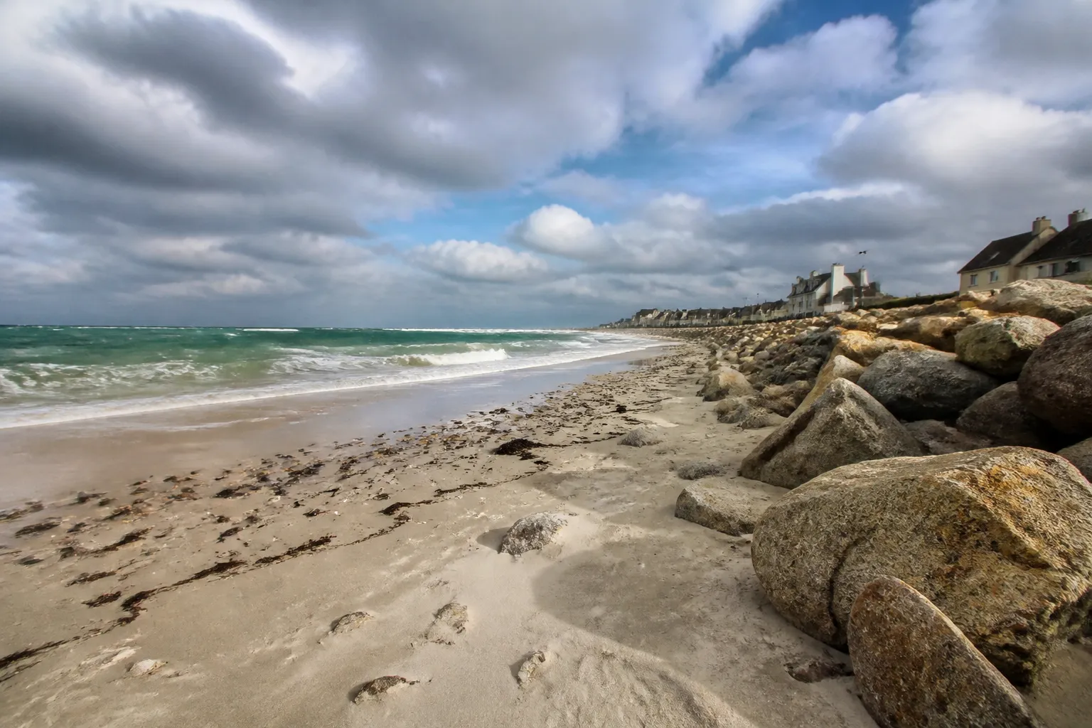 Plage et enrochement sous un ciel venteux