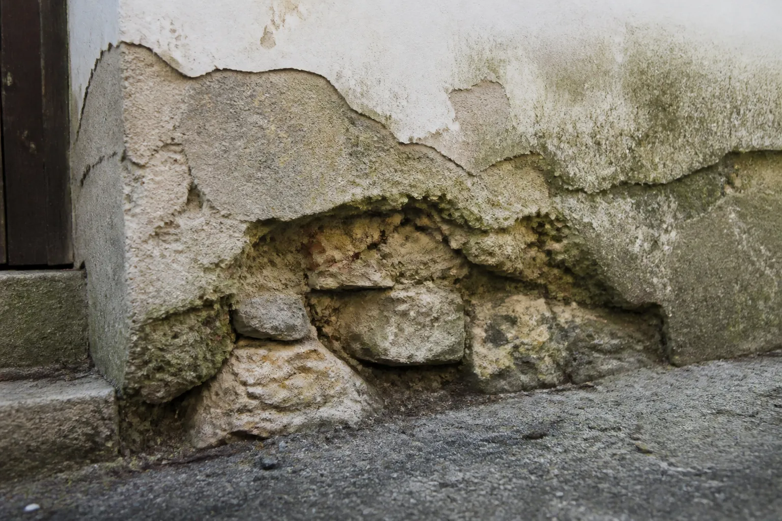 Enduit ancien décollé en pied de mur
