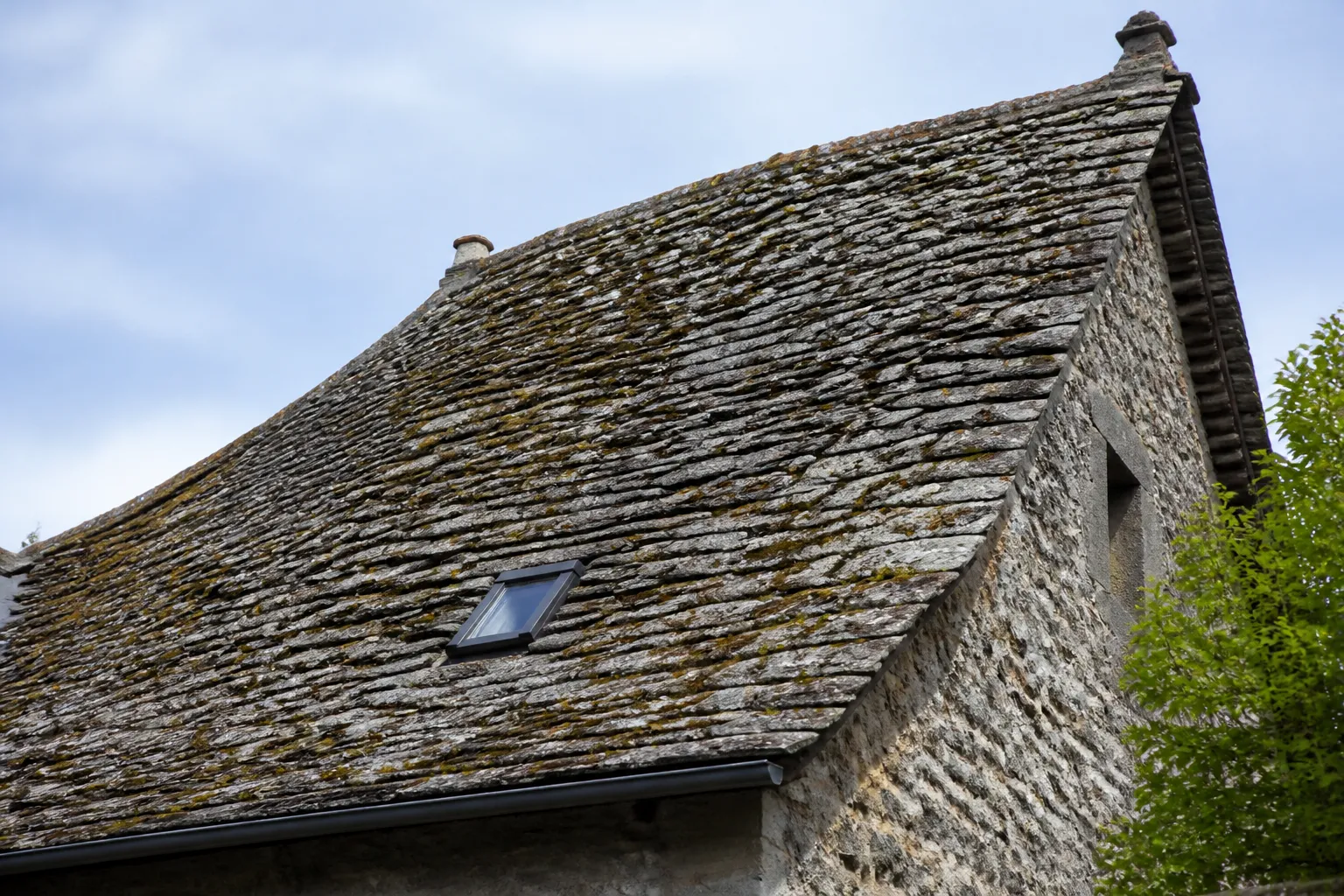 Toiture pentue couverte de pierres plates calcaires