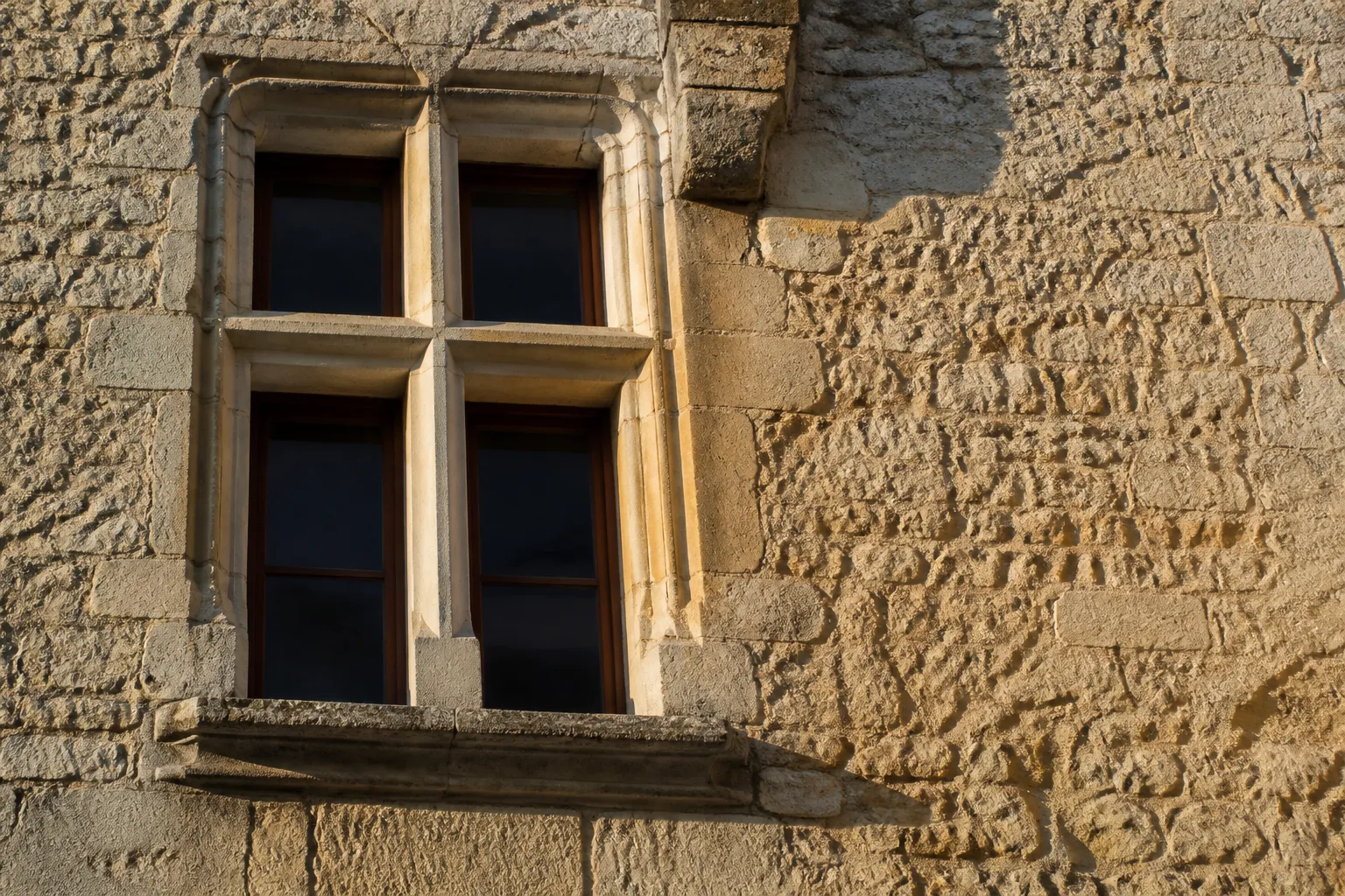 Fenêtre à meneaux en pierre sur une façade ancienne