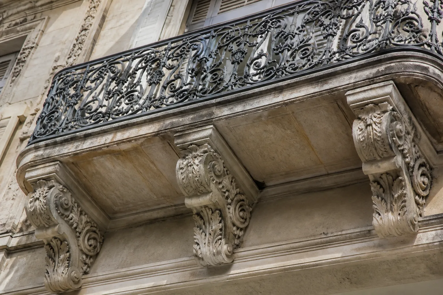 Dessous de balcon en pierre sculptée et garde-corps en fonte
