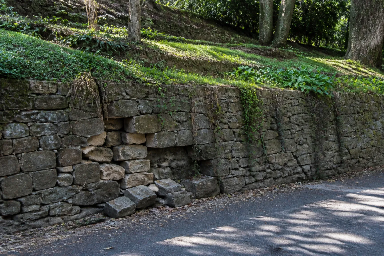Mur de soutènement en pierre au bas d’un jardin en pente
