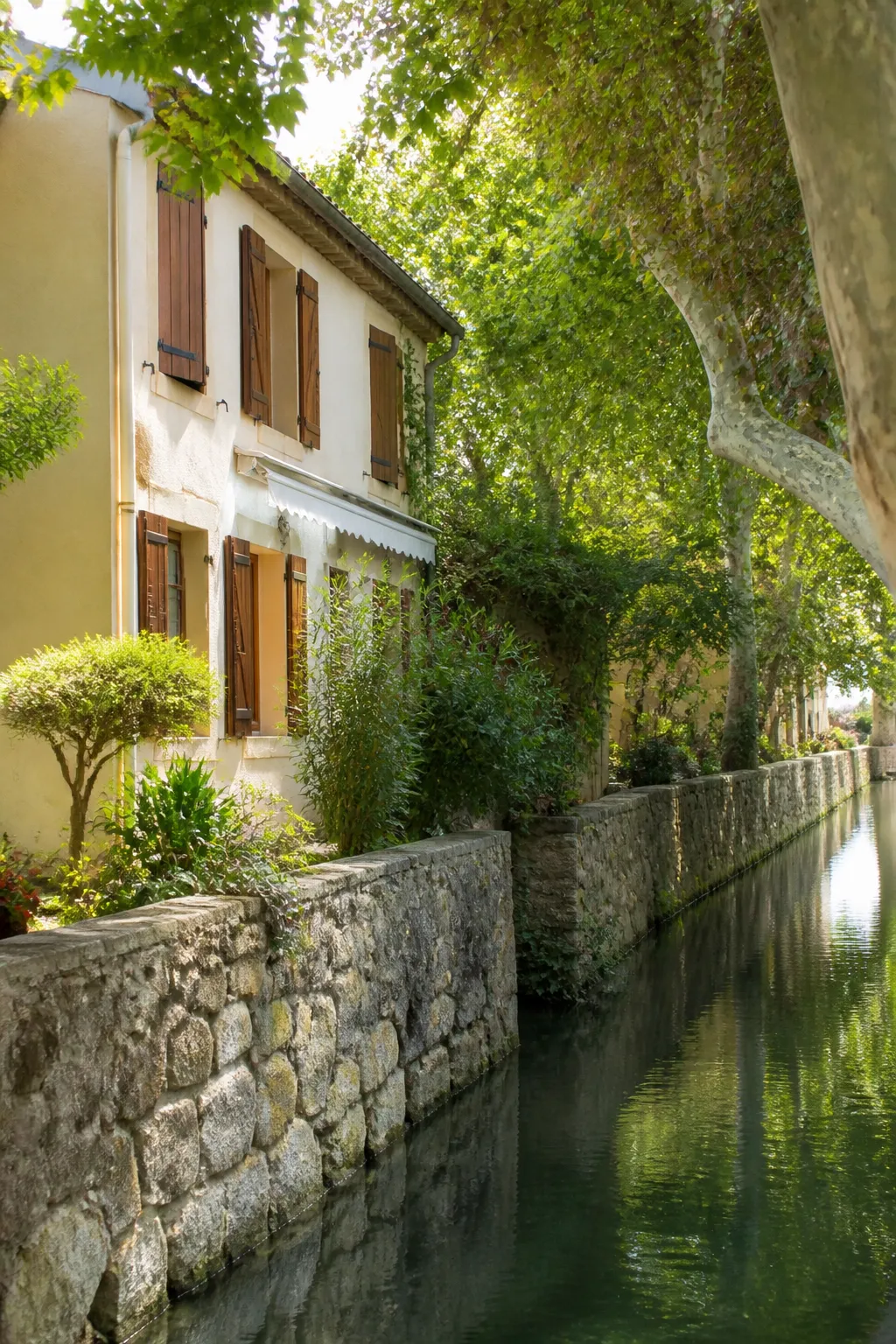 Maison de ville avec jardin longeant un canal arboré