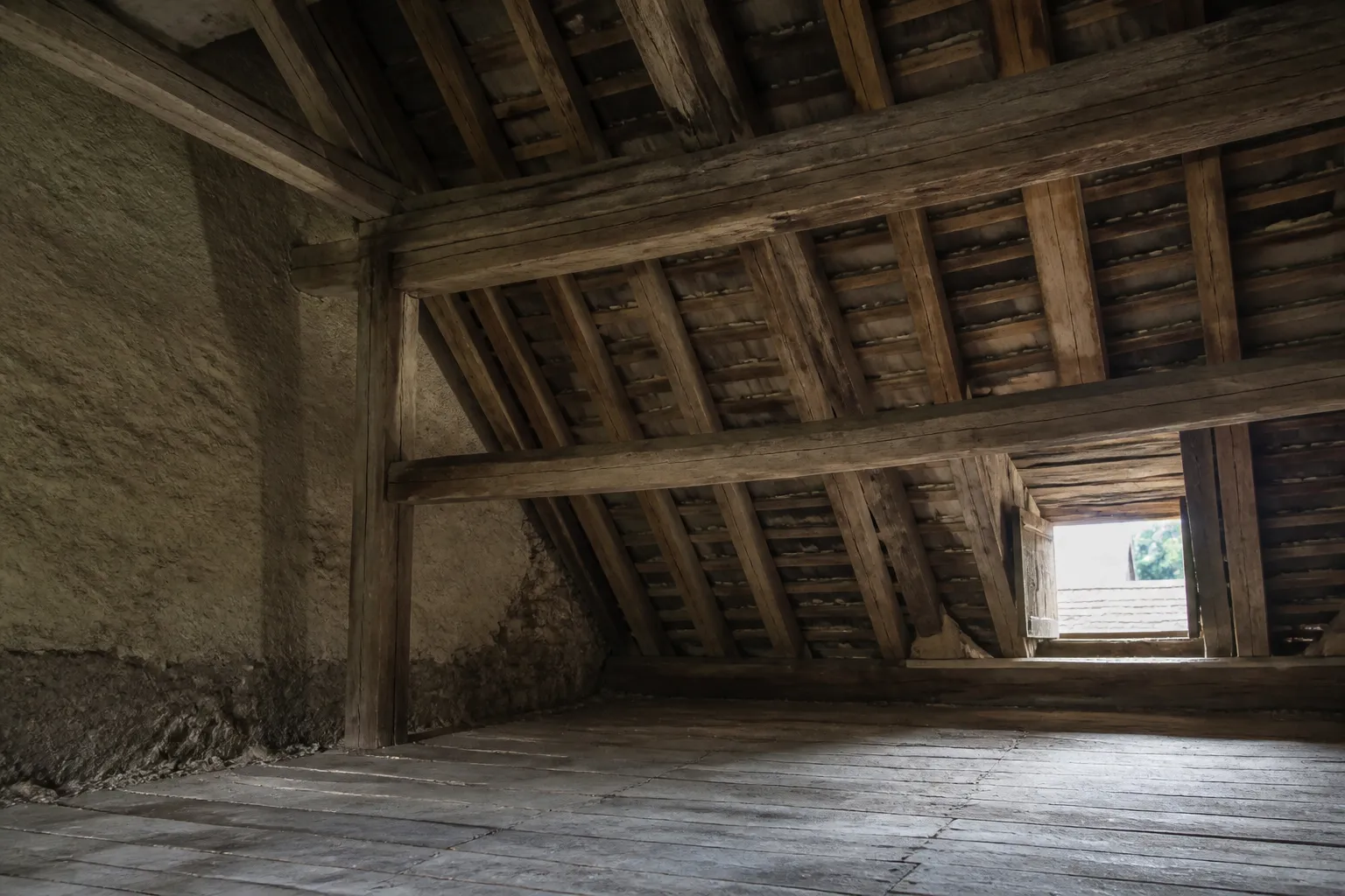 Charpente ancienne en bois observée dans des combles