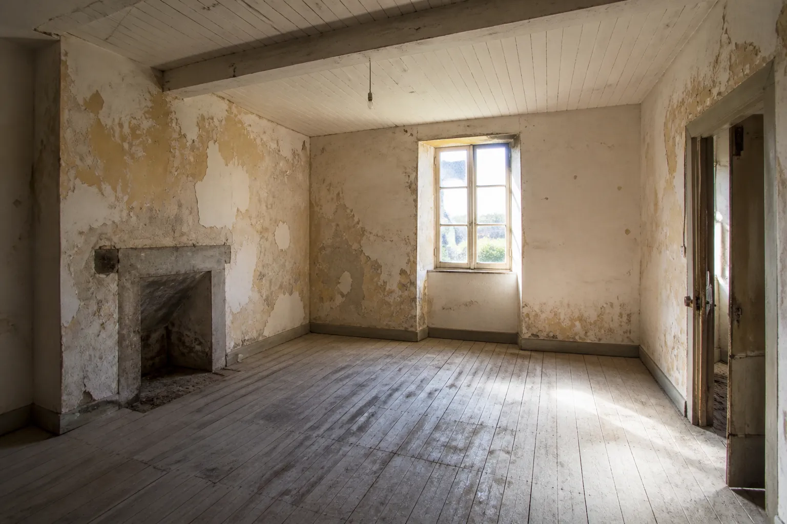 Pièce à rénover avec enduits anciens et plancher bois