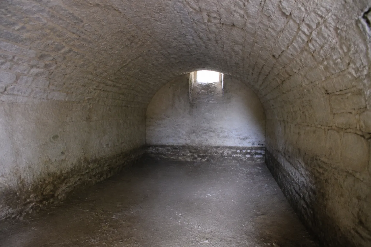 Cave voûtée en pierre avec soupirail
