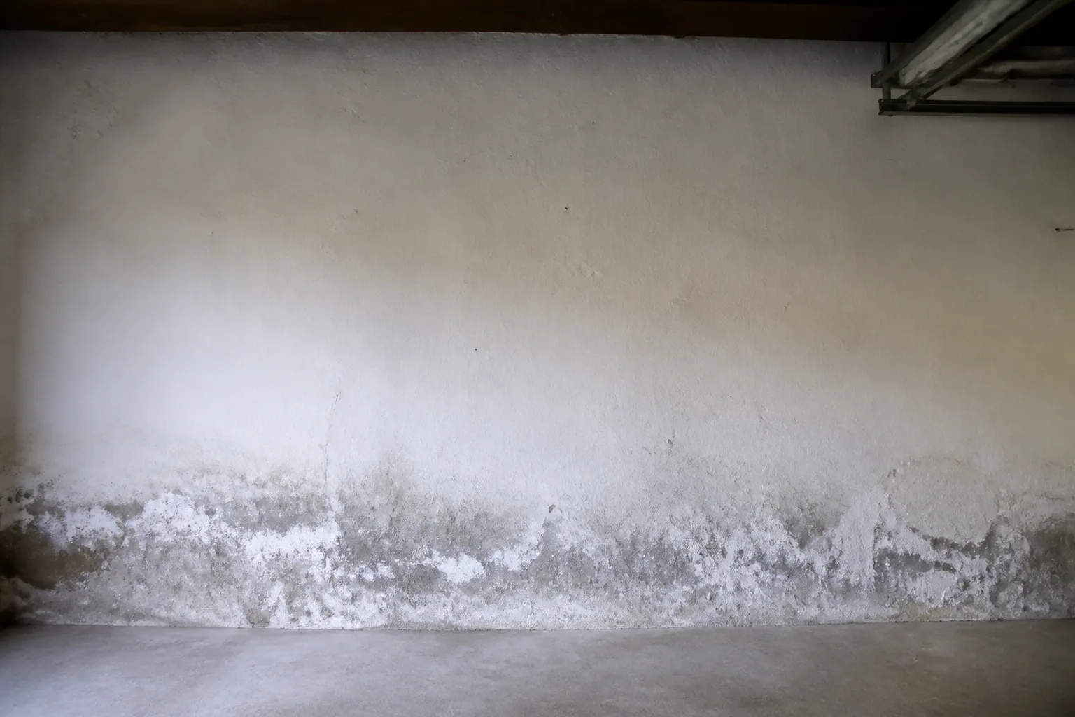Mur de garage en rez-de-chaussée avec traces d’humidité en partie basse