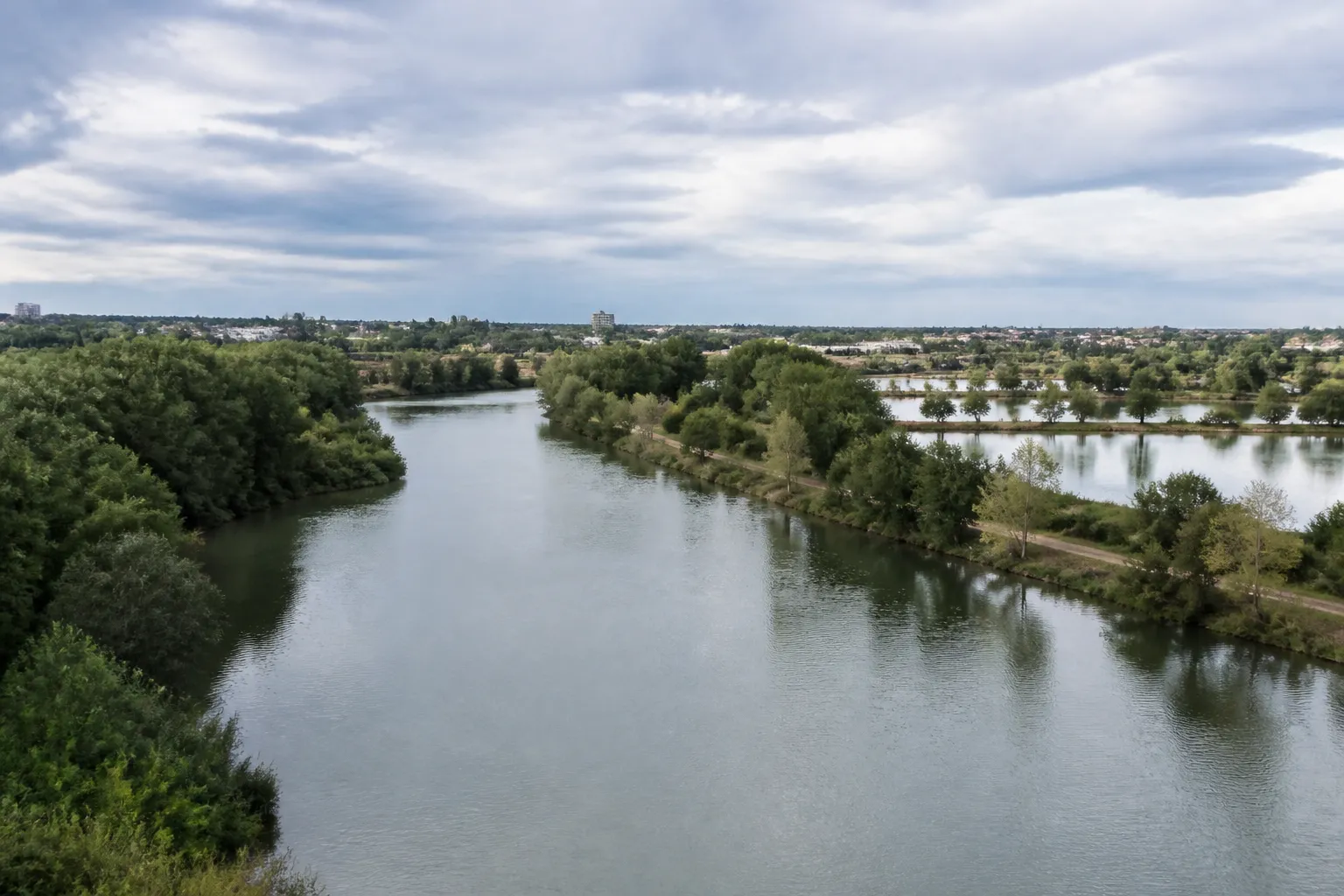 Rivière calme bordée d’arbres et d’étangs en périphérie de ville