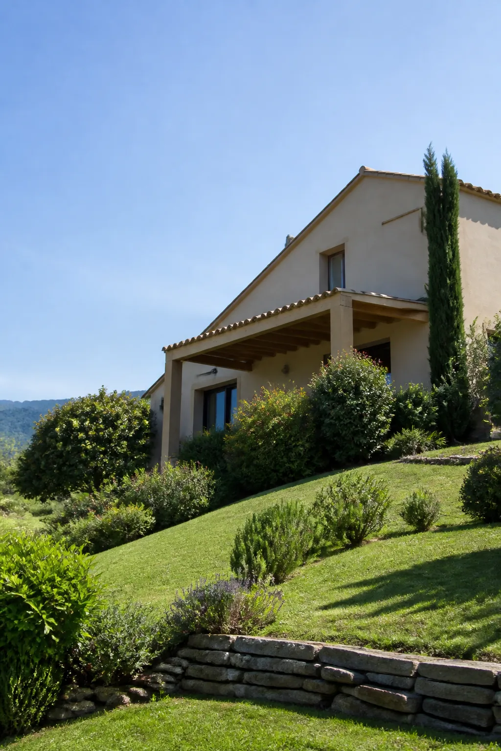 Maison individuelle sur un coteau verdoyant avec jardin en pente