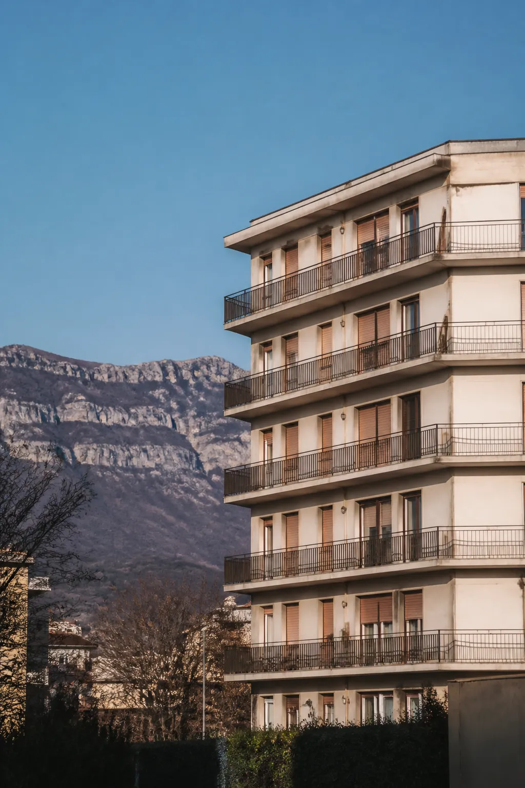 Immeuble de logements des années 1960 avec balcons devant des montagnes