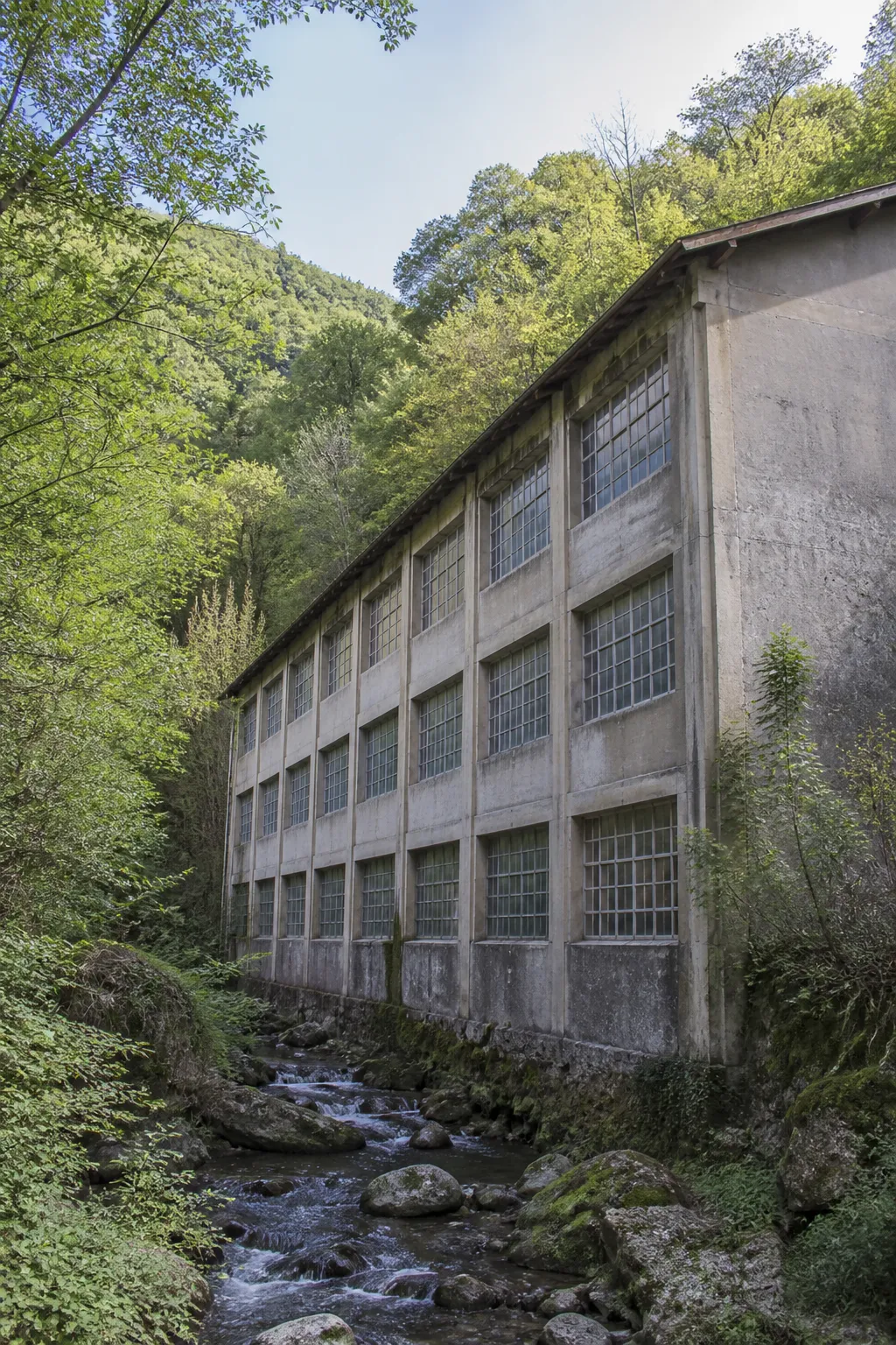 Immeuble ancien à petites fenêtres d’atelier dans une vallée du Haut-Jura