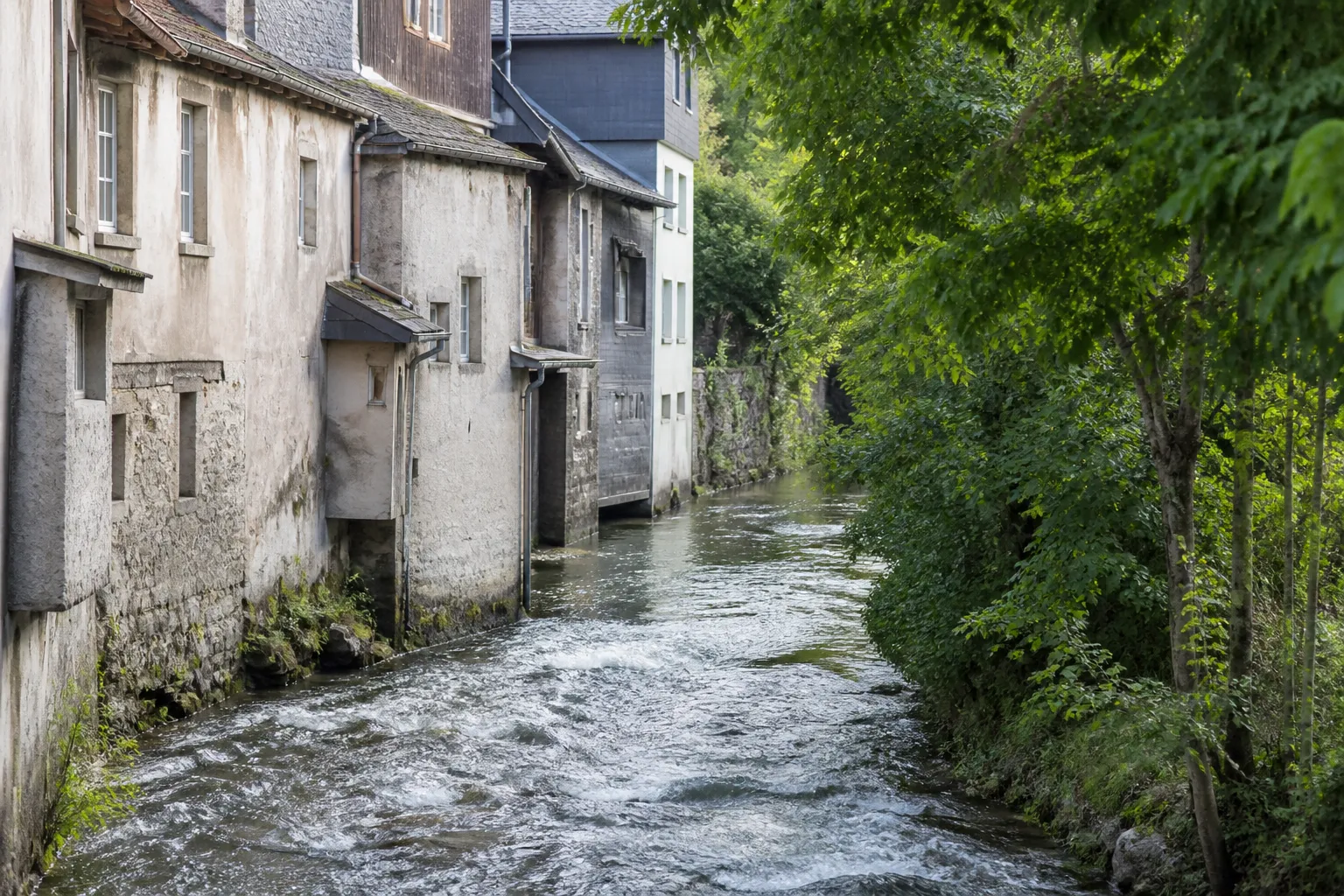 Rivière de montagne longeant des bâtiments anciens