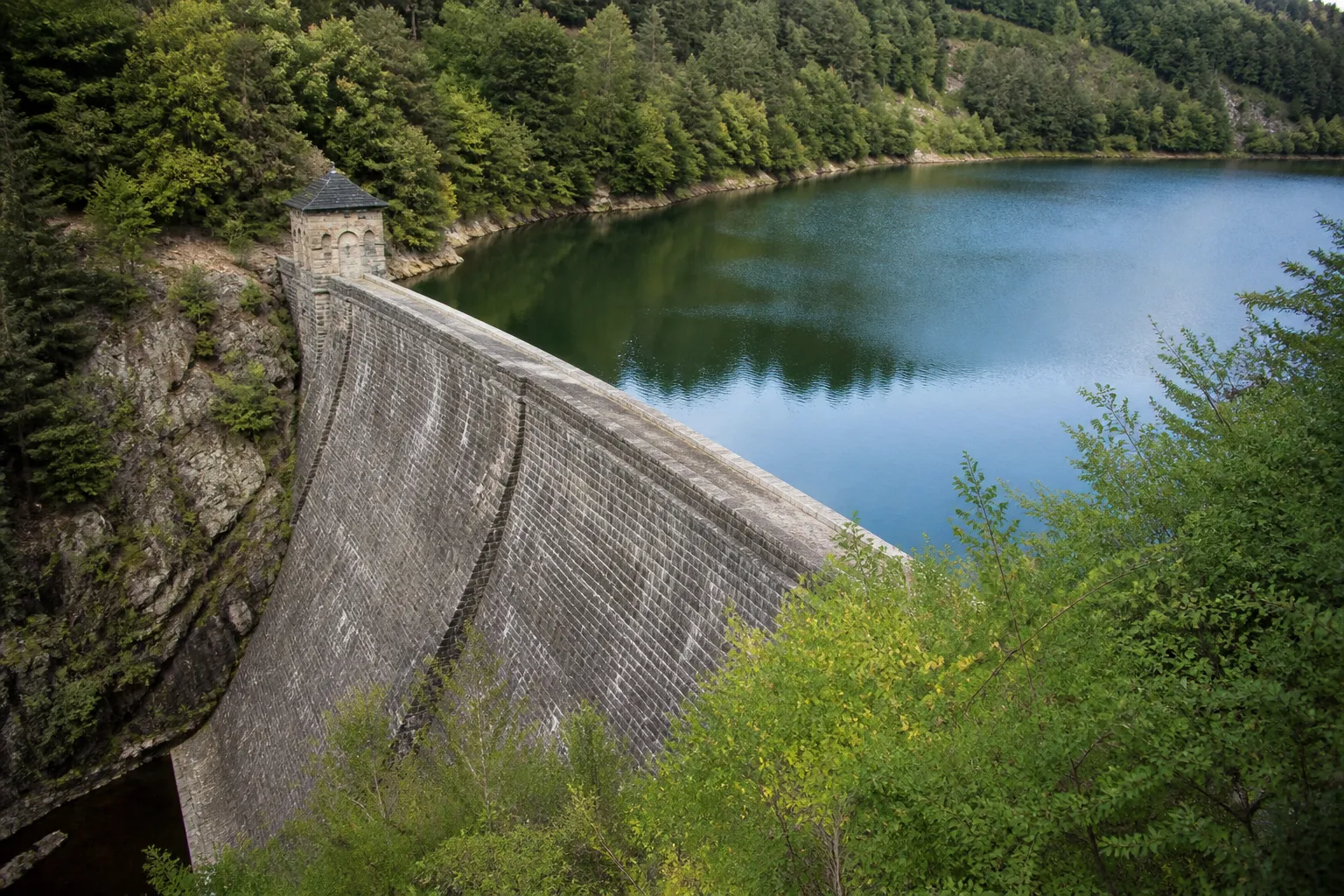 Retenue d’eau d’un barrage ancien en maçonnerie dans une vallée boisée