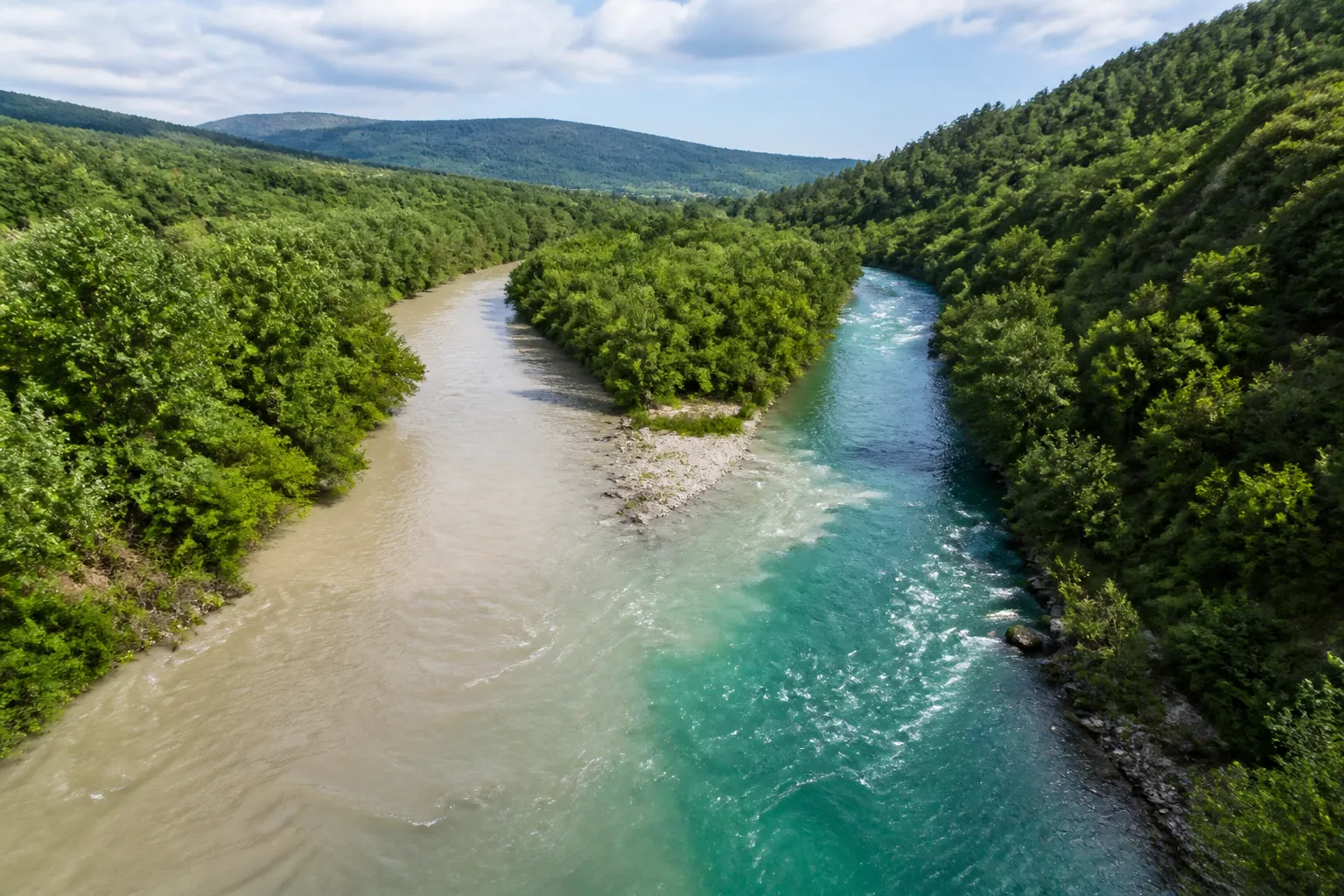 Confluence de deux cours d’eau dans une vallée verte