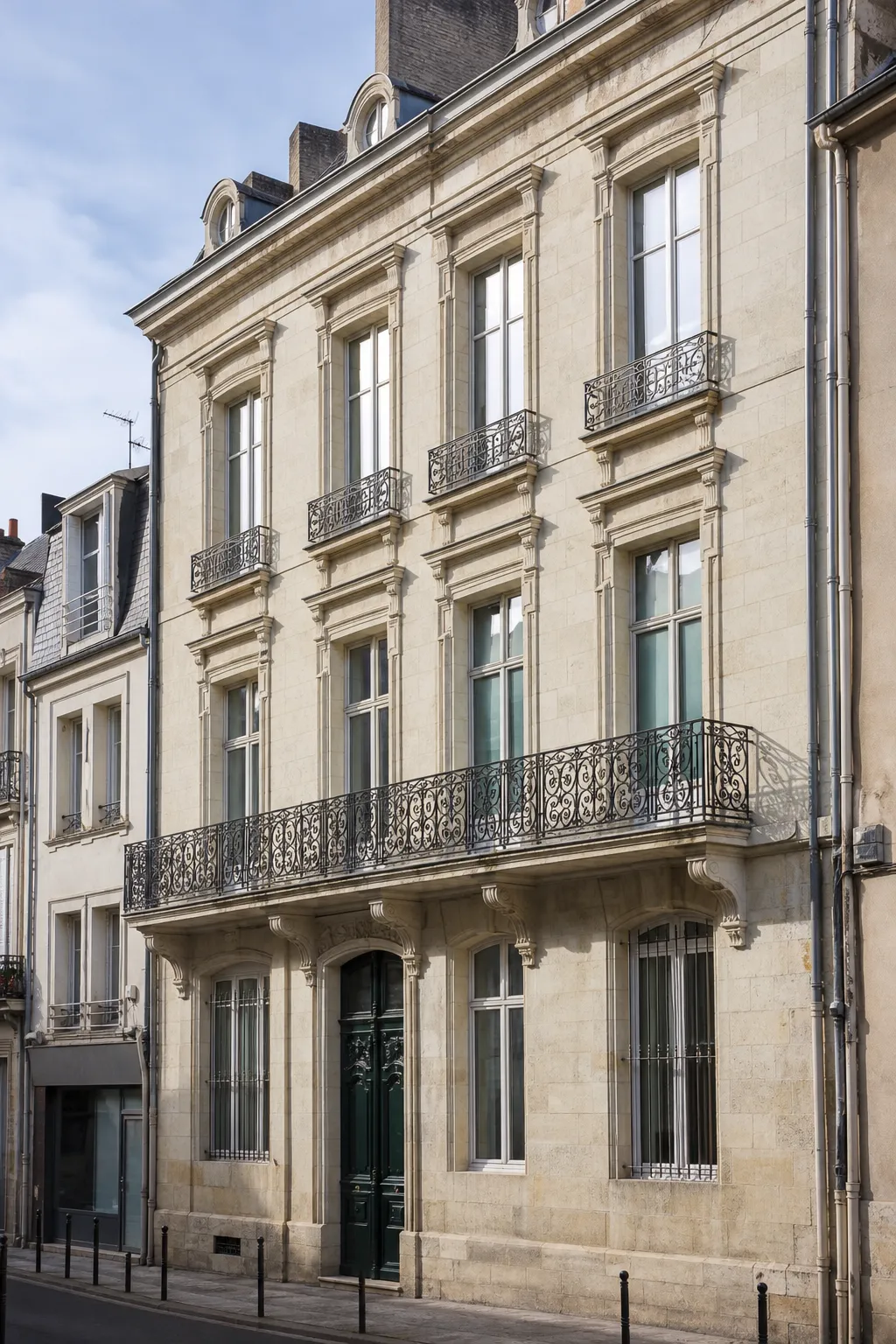 Immeuble ancien en pierre de taille avec balcons dans une rue de centre-ville