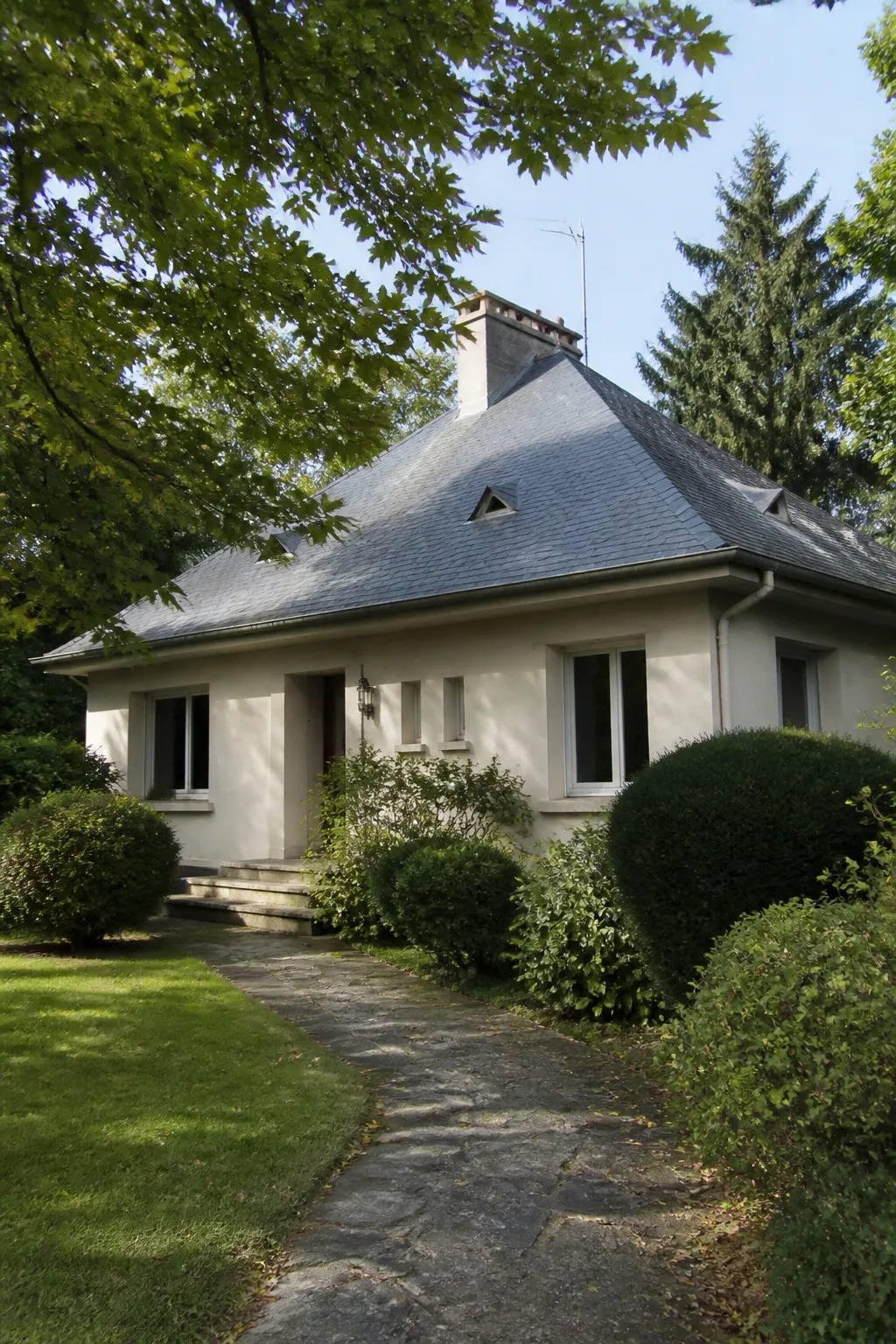 Pavillon avec toiture en ardoise et jardin dans un quartier résidentiel