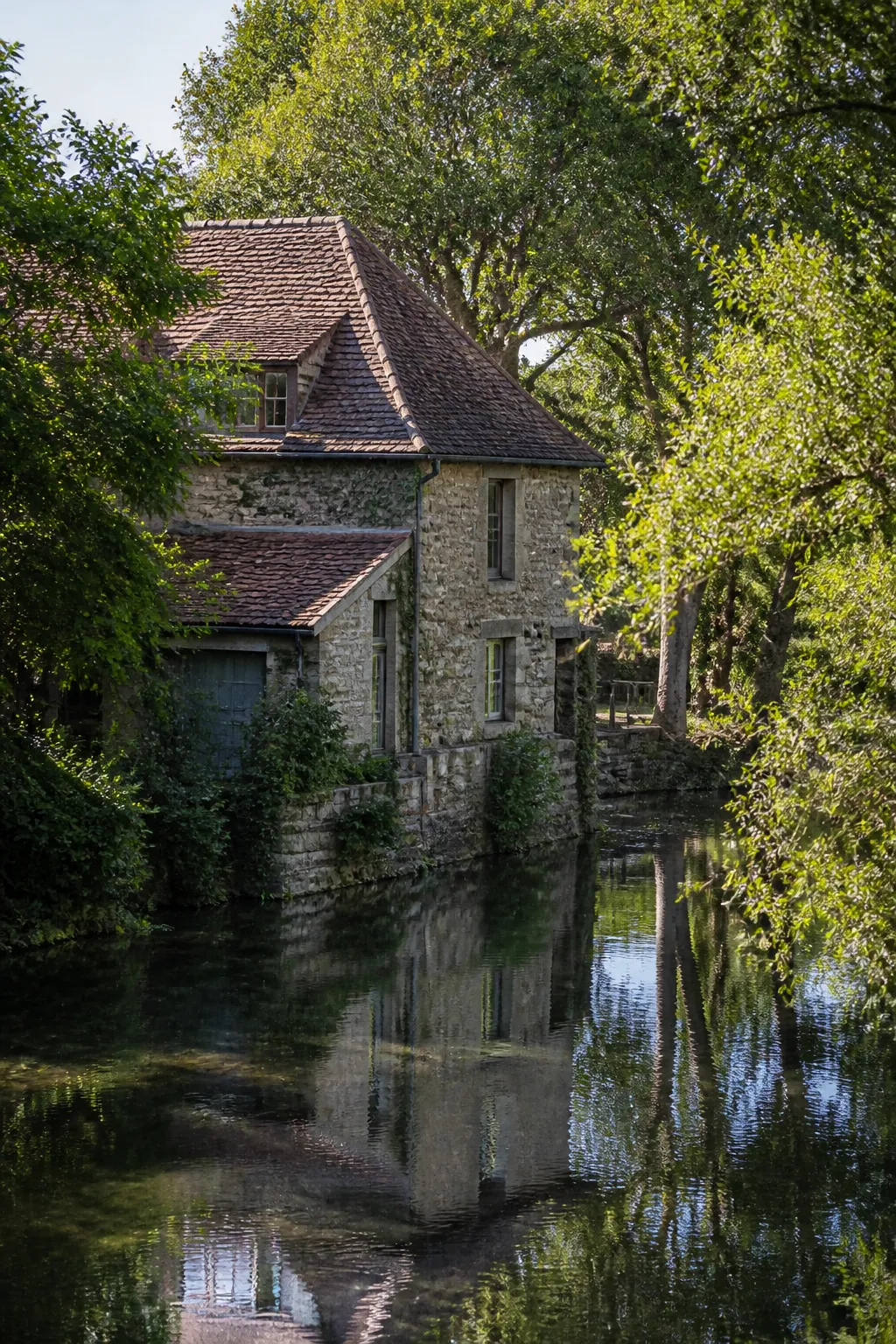 Maison ancienne en pierre au bord d’une rivière