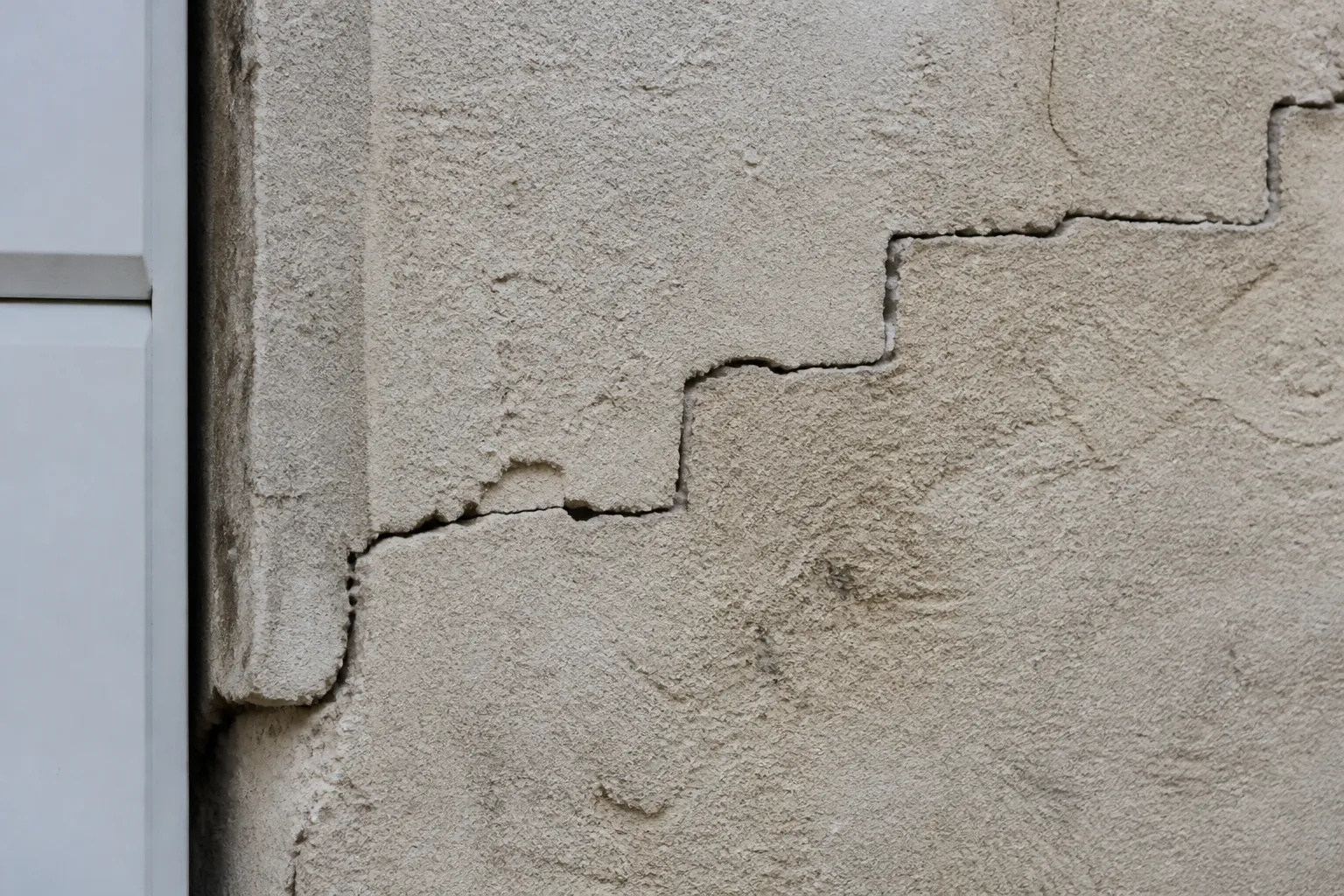 Fissure en escalier sur un mur de maison