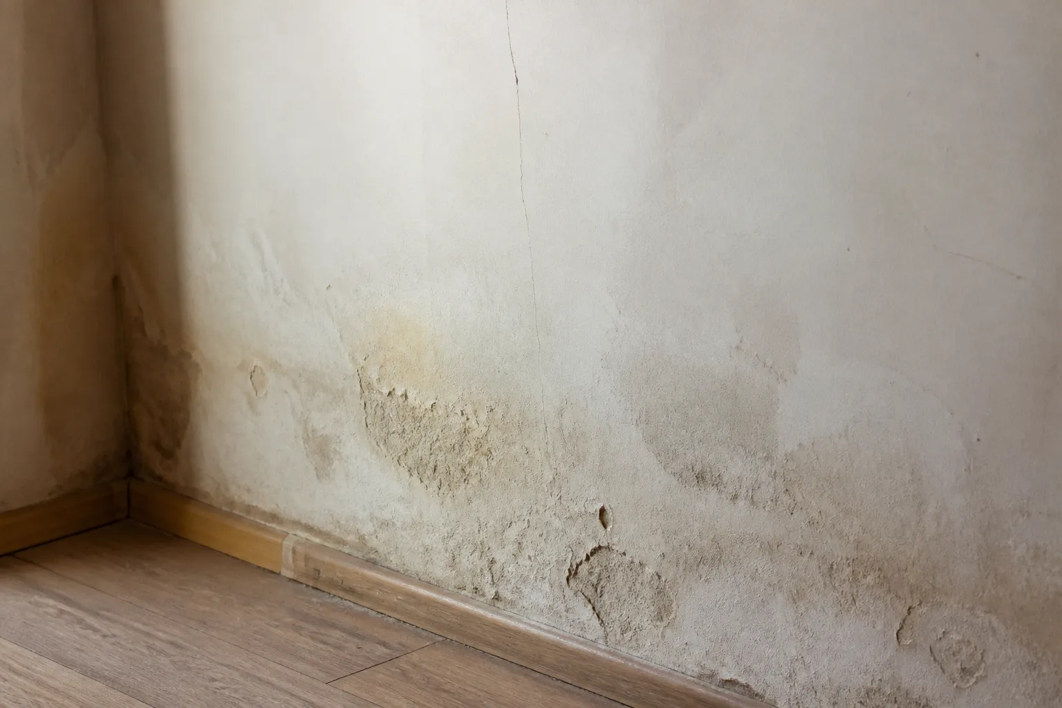 Rez-de-chaussée d’une maison avec traces d’humidité en bas de mur
