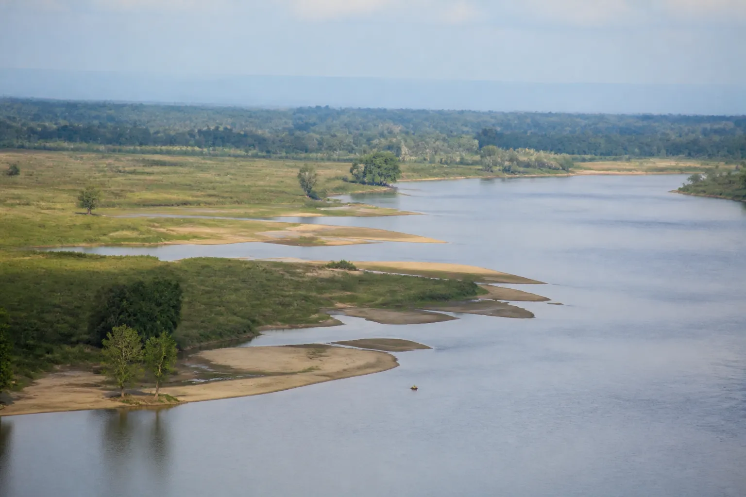 Fleuve large aux berges de sable et prairies inondables
