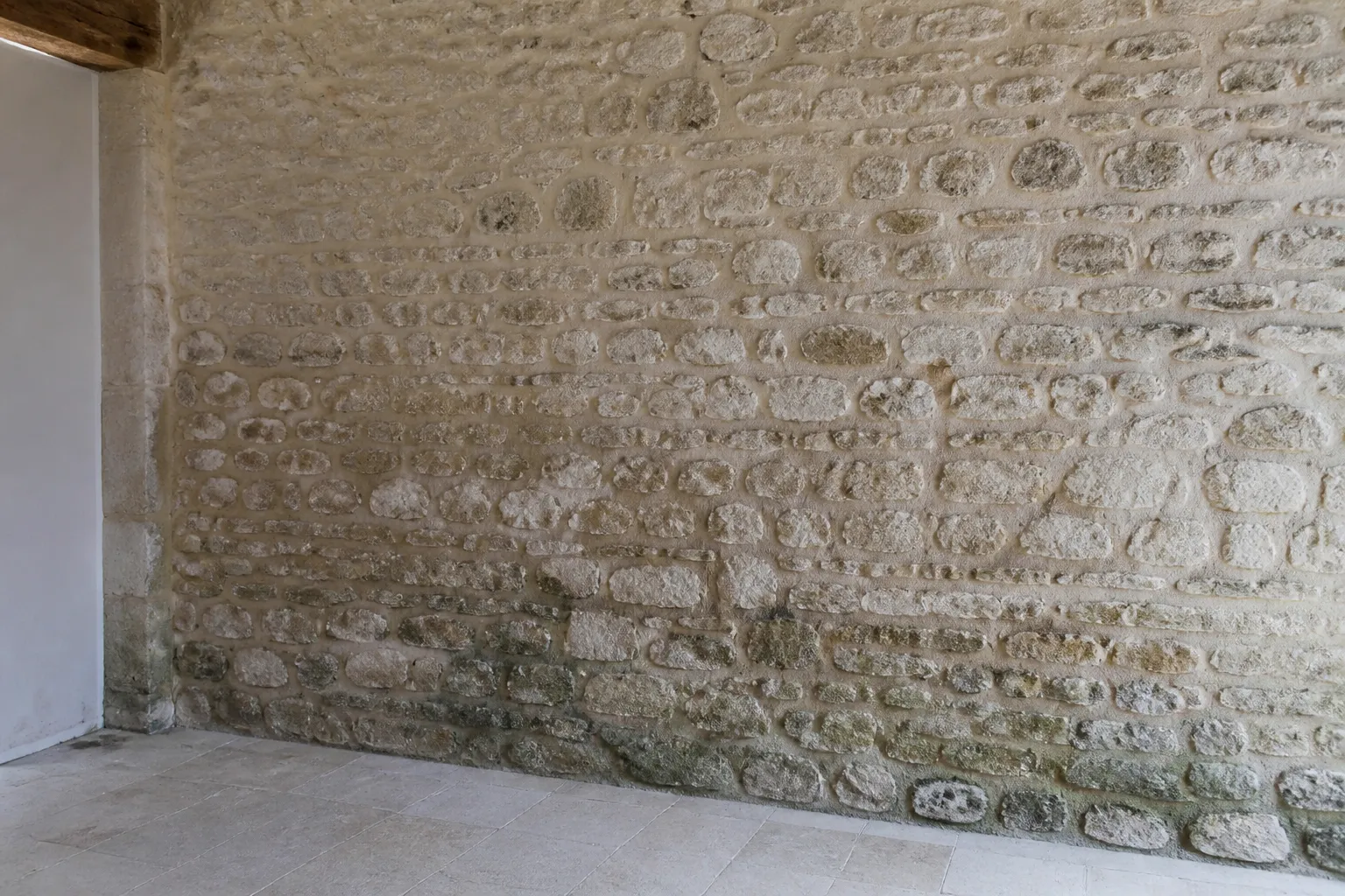 Rez-de-chaussée en pierre avec traces d’humidité anciennes