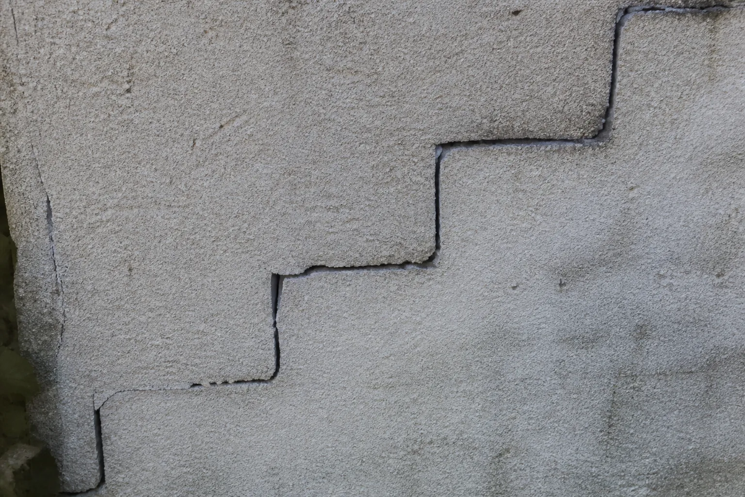 Fissure en escalier sur un mur de clôture