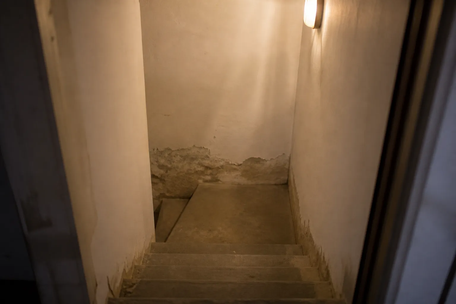 Escalier de sous-sol avec traces d’humidité en pied de mur