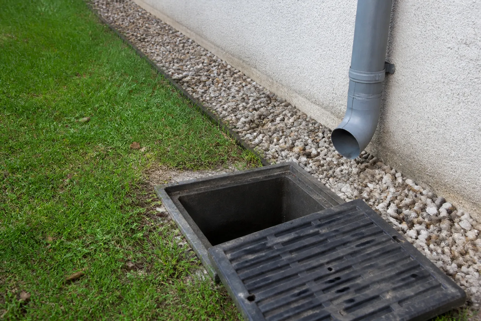 Regard d’eaux pluviales ouvert au pied d’une maison