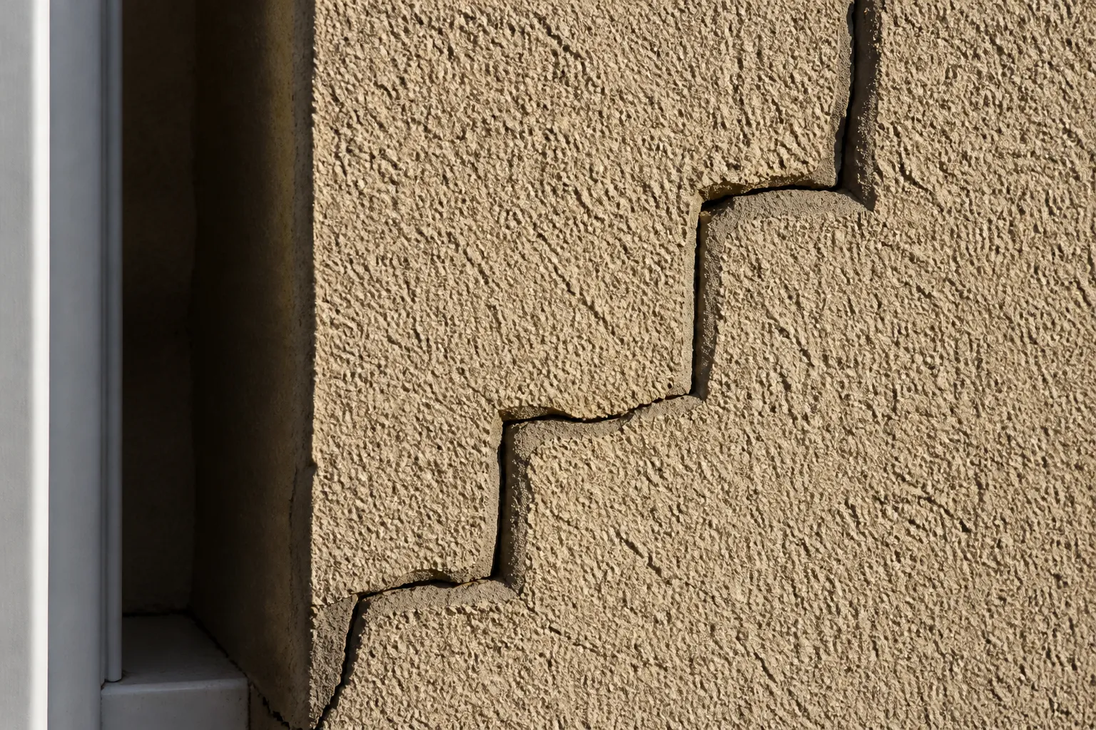 Fissure en escalier sur un mur de pavillon