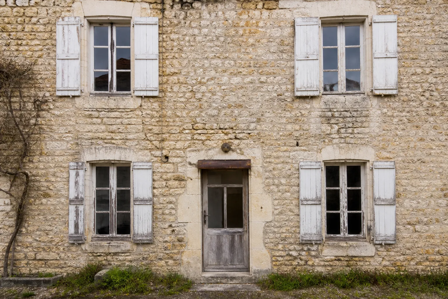 Façade ancienne avec menuiseries en bois à restaurer