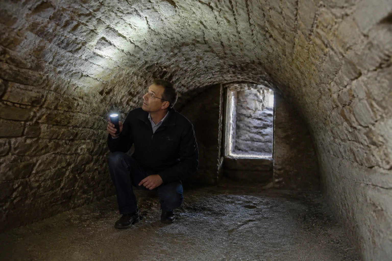 Expert examinant une cave voûtée en pierre