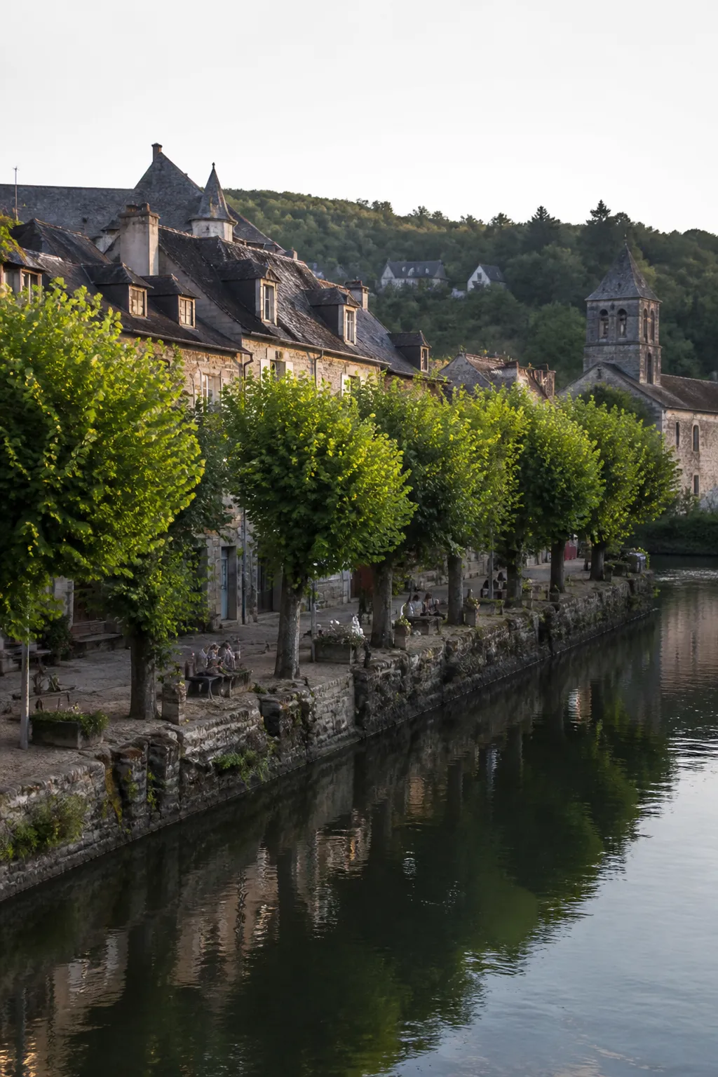 Petite ville ancienne au bord d’un fleuve avec quais arborés