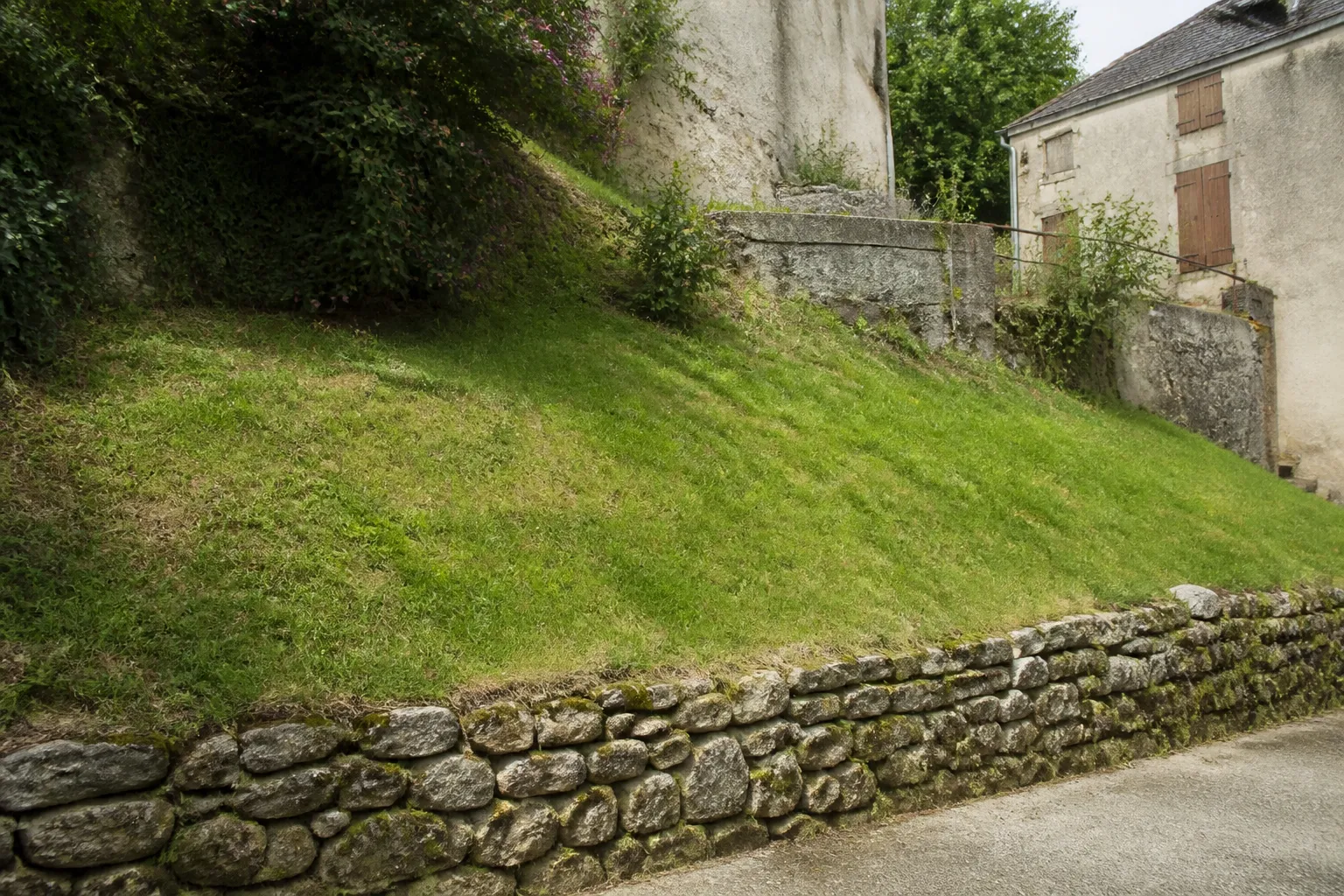 Talus herbeux derrière une maison de bourg