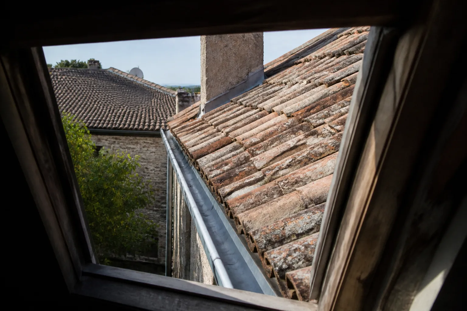 Toiture de tuiles vue depuis une fenêtre de comble