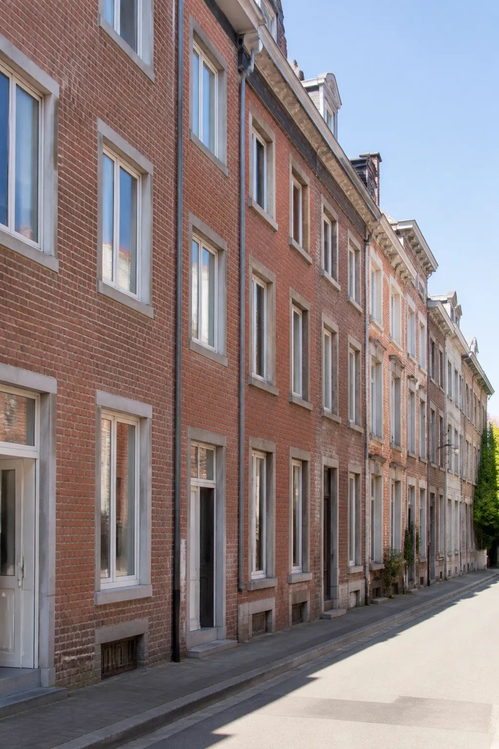 Maisons de ville en brique alignées sous un ciel clair