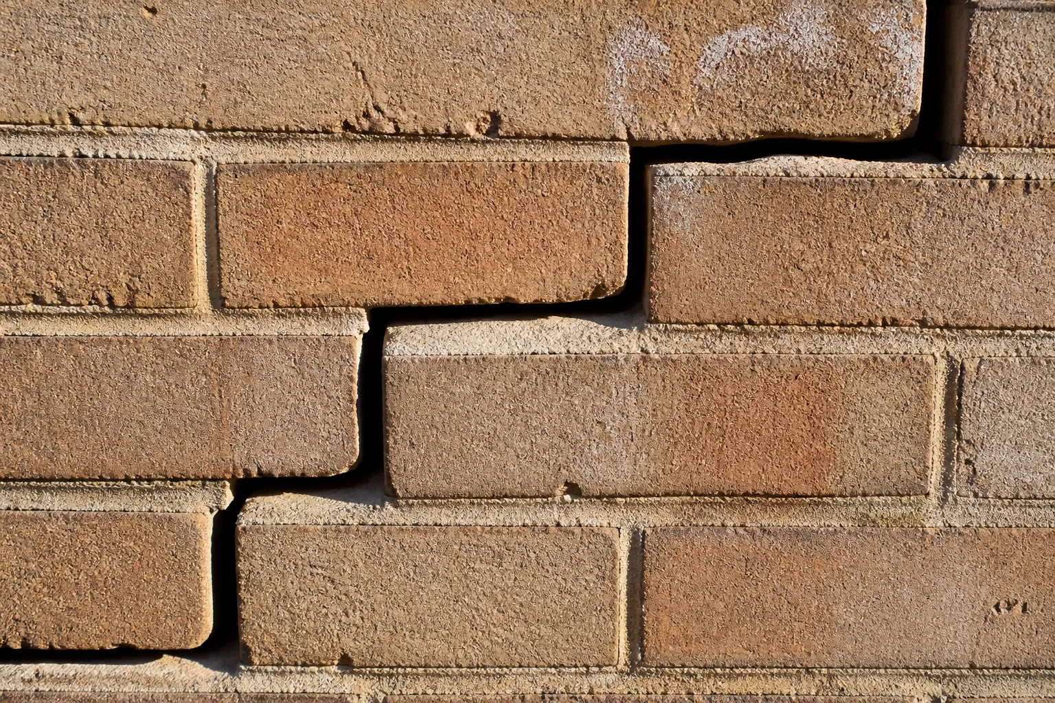 Fissure en escalier sur un mur de brique