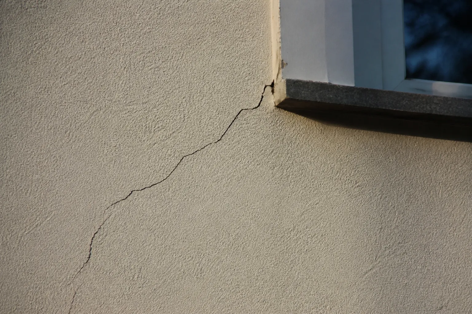 Fissure oblique sur un enduit de façade